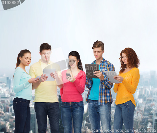 Image of group of teenagers with smartphones and tablet pc