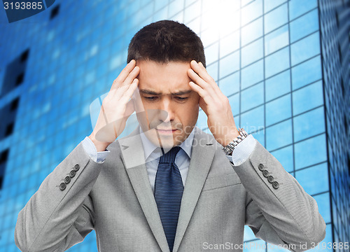 Image of businessman in suit having head ache