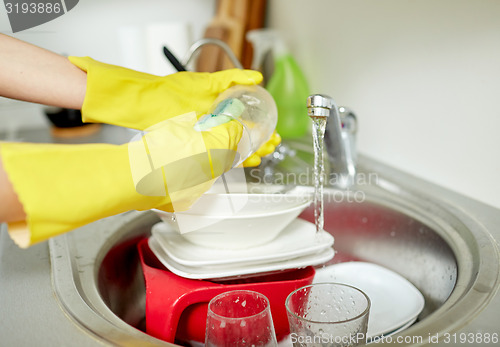 Image of close up of woman hands washing dishes in kitchen
