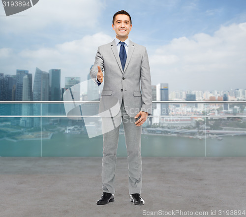 Image of happy smiling businessman in suit shaking hand