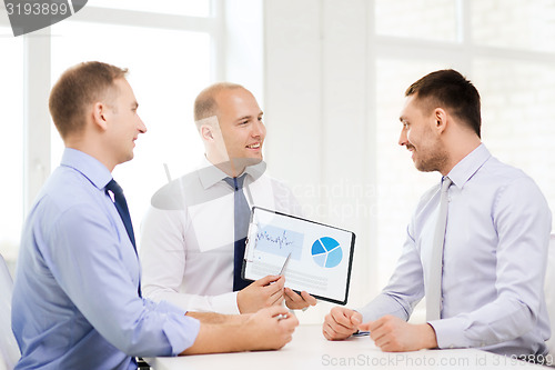 Image of smiling businessmen with papers in office