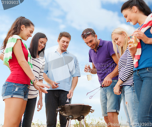 Image of group of friends having picnic on beach