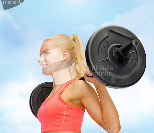 Image of smiling sporty woman exercising with barbell