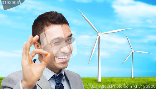 Image of happy businessman in suit showing ok hand sign