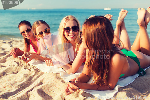 Image of group of smiling women in sunglasses on beach