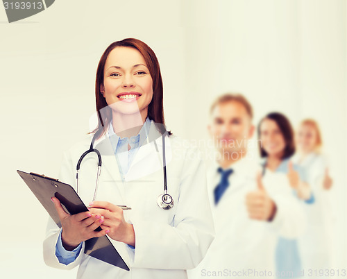 Image of smiling female doctor with clipboard