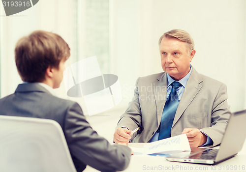 Image of older man and young man having meeting in office