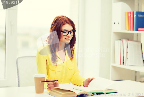 Image of smiling student girl reading books in library