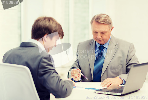 Image of older man and young man having meeting in office