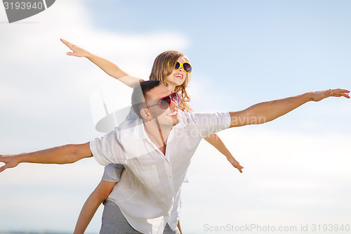 Image of happy father and child in sunglasses over blue sky