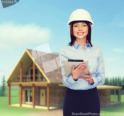 Image of young smiling businesswoman in white helmet