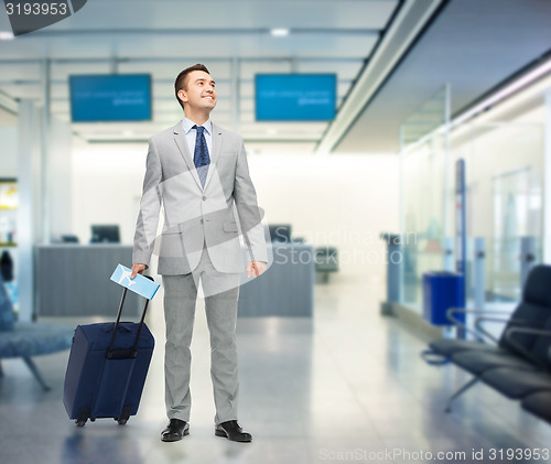 Image of happy businessman in suit with travel bag