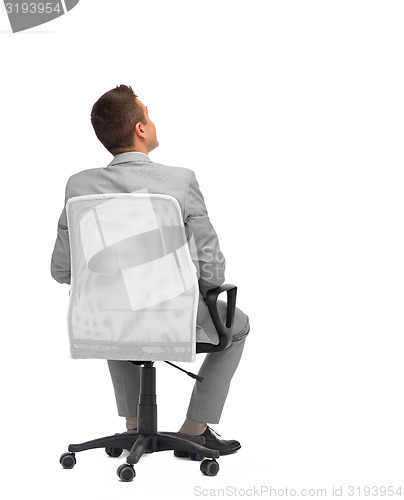 Image of businessman sitting in office chair from back