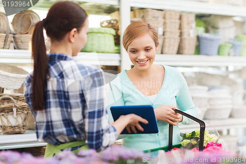 Image of happy women with tablet pc at flower shop