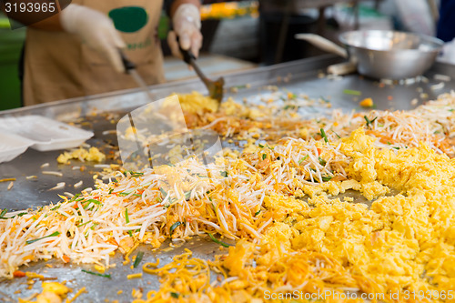 Image of close up of cook frying wok at street market