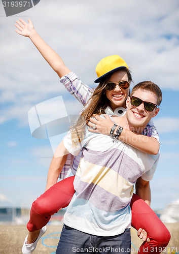 Image of smiling teenagers in sunglasses having fun outside