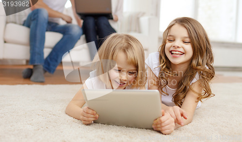 Image of smiling sister with tablet pc and parents on back