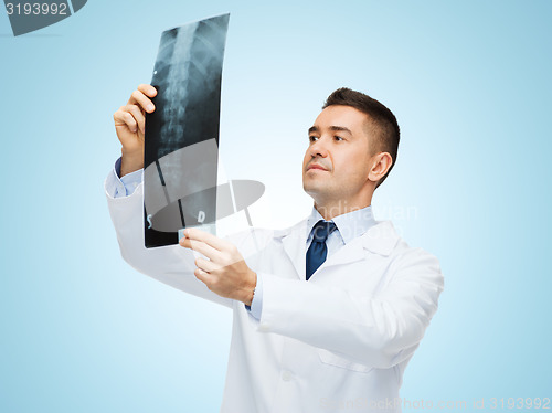 Image of male doctor in white coat looking at x-ray