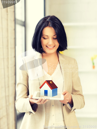 Image of woman holding tablet pc with house illustration