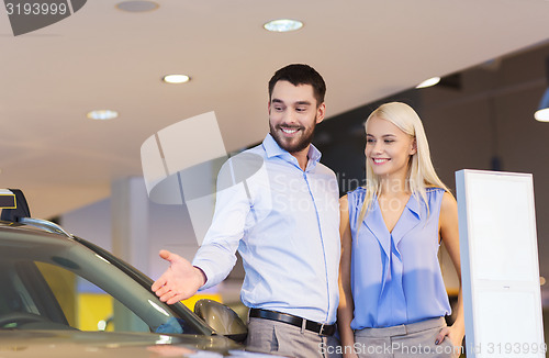 Image of happy couple buying car in auto show or salon