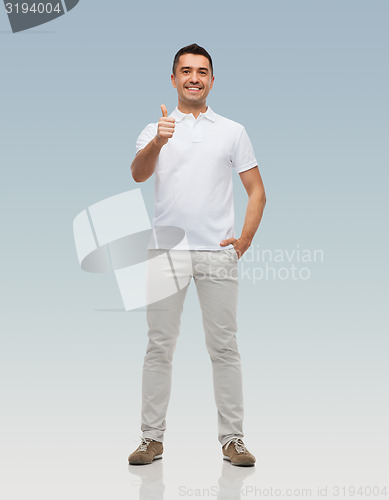 Image of smiling man showing thumbs up over gray background