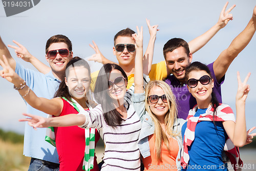 Image of group of happy friends having fun on beach