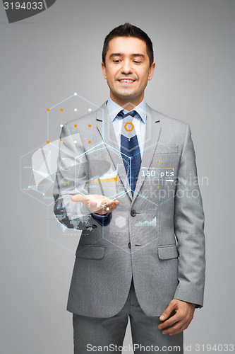 Image of happy businessman in suit showing virtual screens