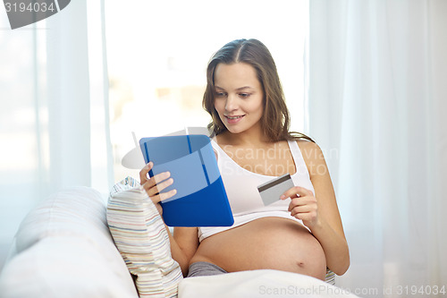 Image of pregnant woman with tablet pc and credit card