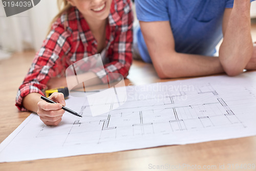 Image of close up of couple with  blueprint at home