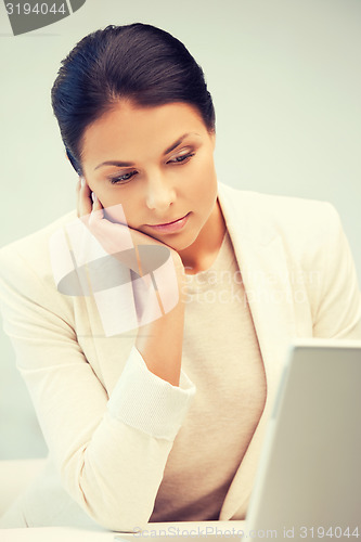 Image of pensive woman with laptop computer
