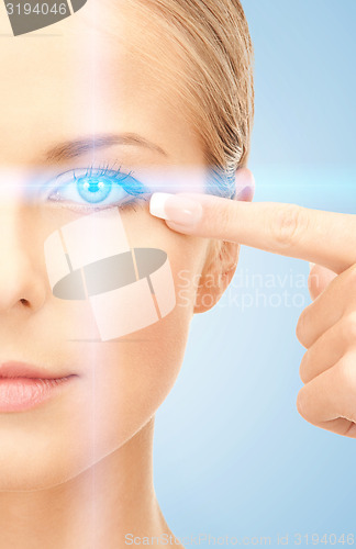 Image of beautiful woman pointing to eye