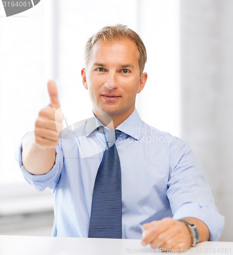 Image of smiling businessman showing thumbs up