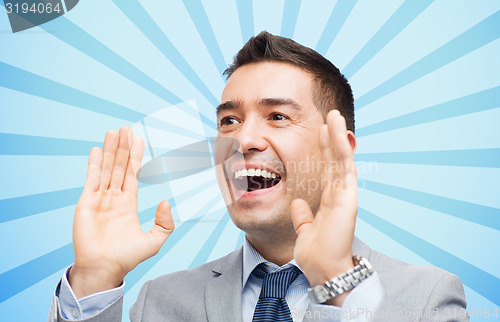Image of happy businessman in suit shouting