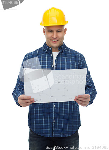 Image of smiling male builder in helmet with blueprint