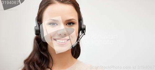 Image of friendly female helpline operator with headphones