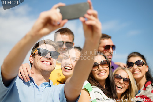 Image of group of friends taking selfie with cell phone