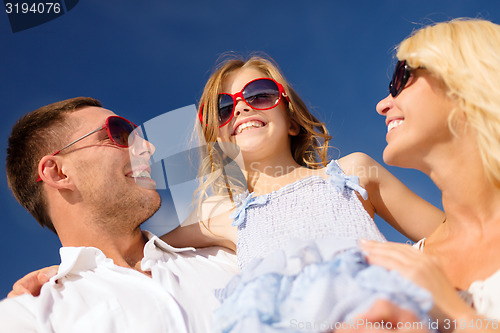 Image of happy family in sunglasses over blue sky
