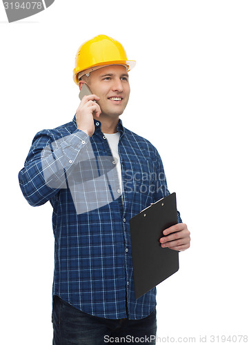 Image of smiling male builder in helmet with clipboard