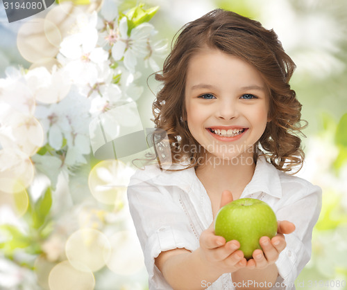 Image of happy girl holding apple over garden background