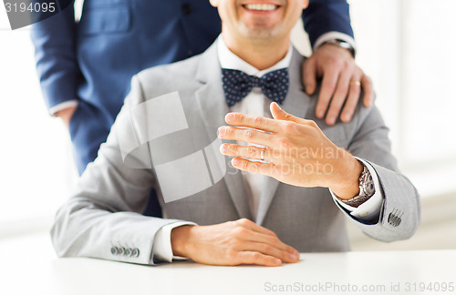 Image of close up of male gay couple with wedding rings on