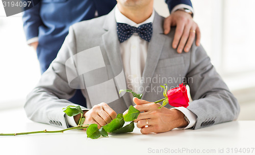 Image of close up of male gay couple with wedding rings on