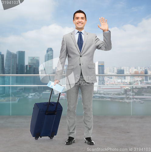 Image of happy businessman in suit with travel bag