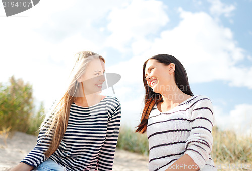 Image of happy teenage girls or young women on beach