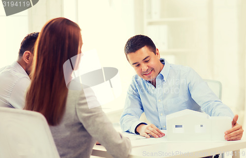 Image of couple looking at model of their house at office