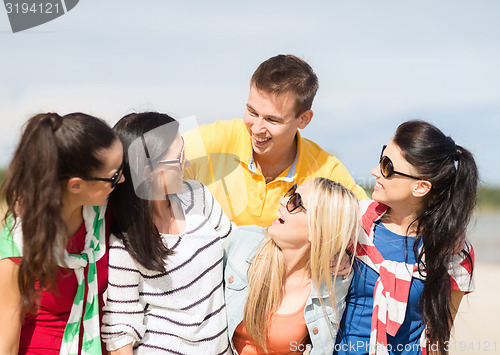 Image of group of happy friends having fun on beach