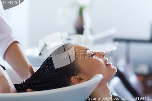 Image of happy young woman at hair salon