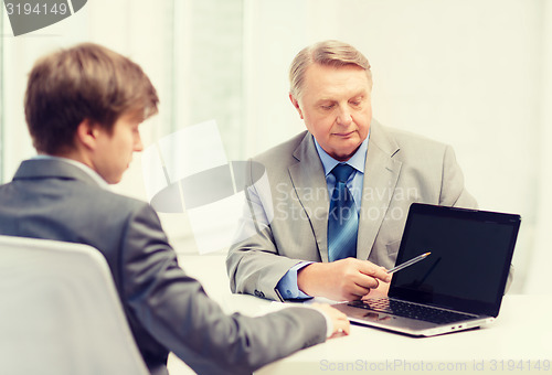 Image of older man and young man with laptop computer