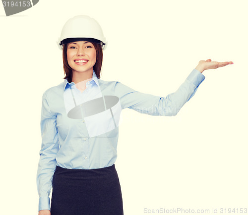 Image of businesswoman in helmet holding something on palm