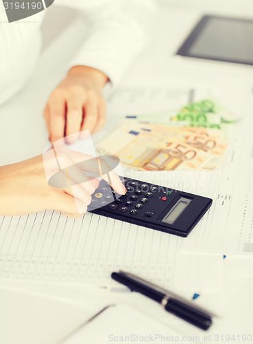 Image of woman hand with calculator and euro money