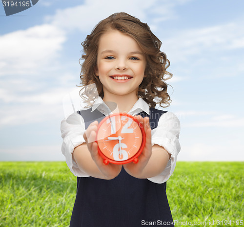 Image of happy girl with alarm clock over summer background